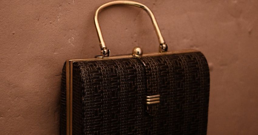 Retro Trends - Vintage bag with golden handle placed on reflecting surface as accessory for garment