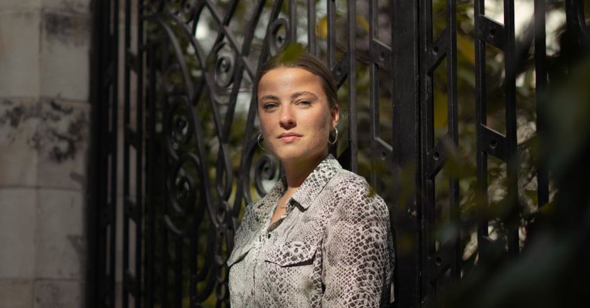 Updo - A woman is standing in front of a gate