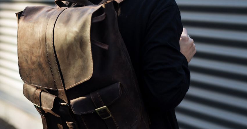 Short Hair - Woman Carrying Brown Leather Backpack Posing in Front of Roll-up Door at Daytime