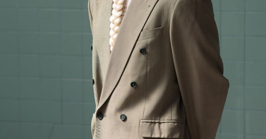 Braided Updos - A man in a suit standing in a locker room