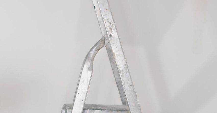 Flat Irons - Metallic step ladder on floor against white wall in room during repair works